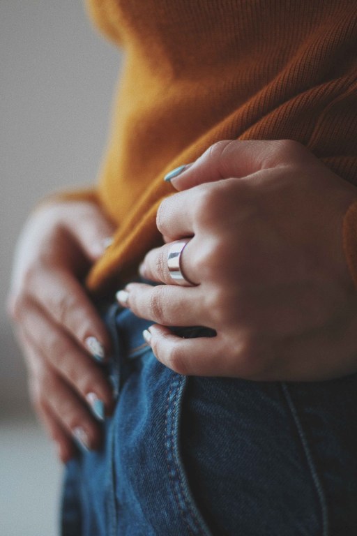 vertical-closeup-shot-female-orange-shirt-wearing-expensive-golden-ring.jpg